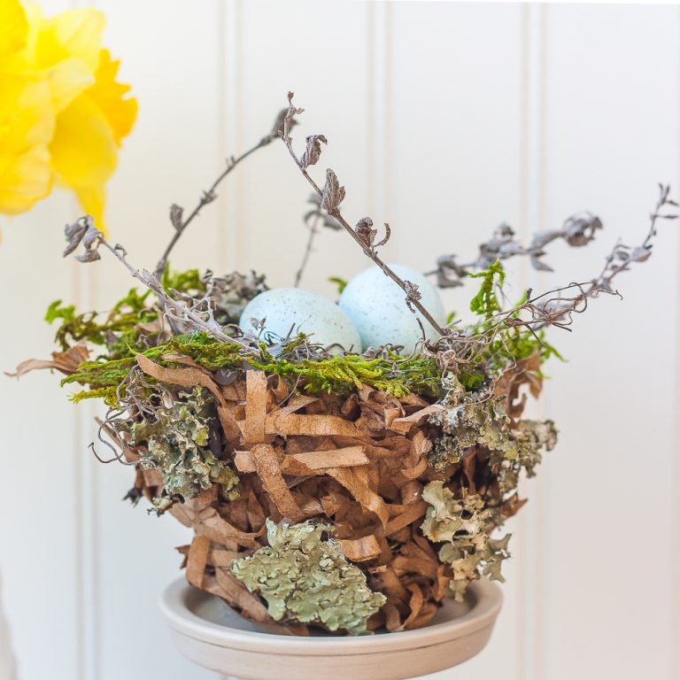 Spring nest made with a paper bag and embellished with moss, twigs, and lichen.