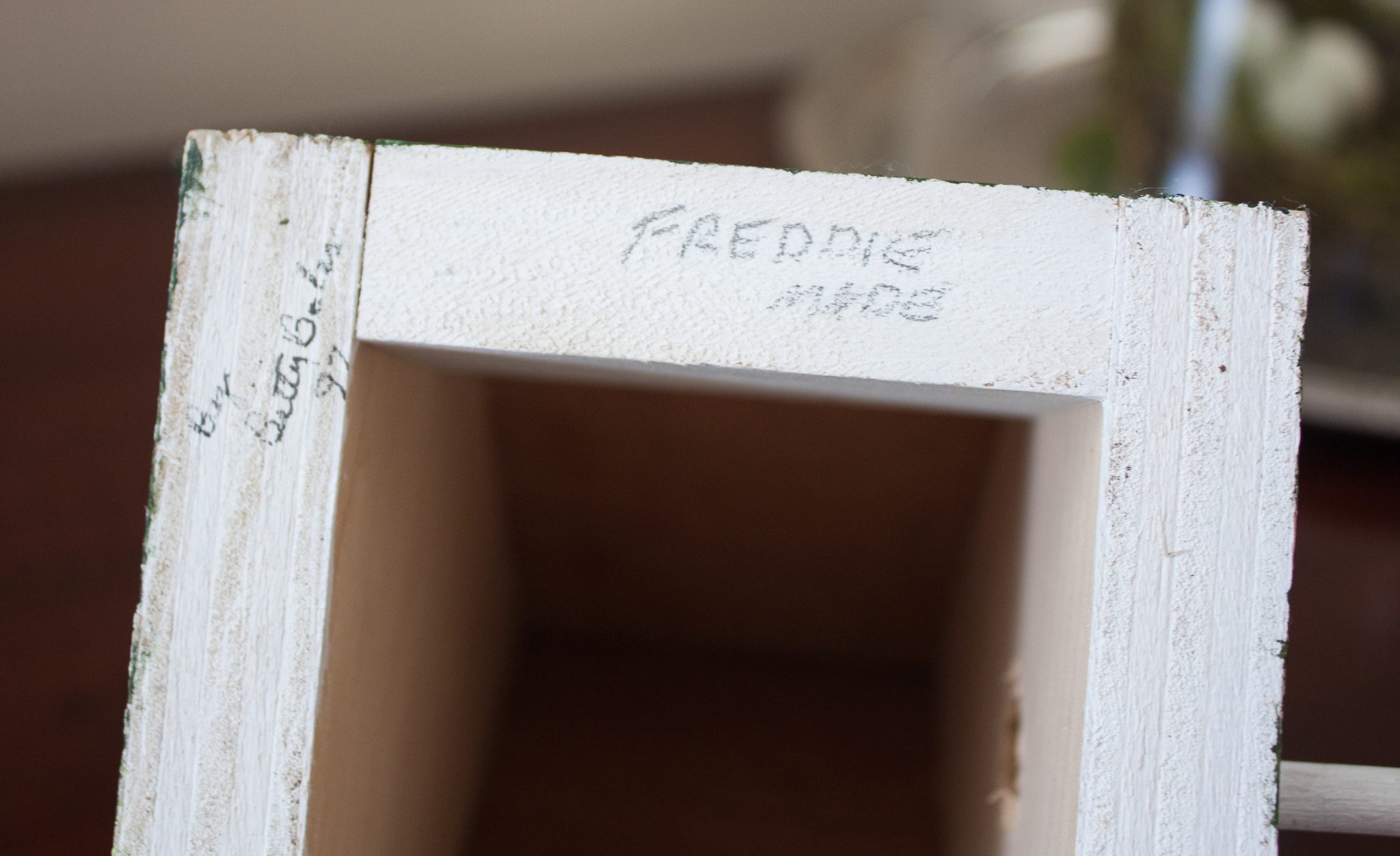 Writing on the bottom of a handmade birdhouse